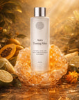 Aura Toning Mist bottle with citrine crystal and fruits on a warm-toned background