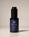 A 30 ml bottle of Divinum Aurelia Serum, featuring a dark purple label and a black dropper cap, set against a neutral light gray background.