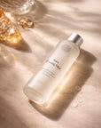 Aura Toning Mist bottle on a textured surface with soft lighting
