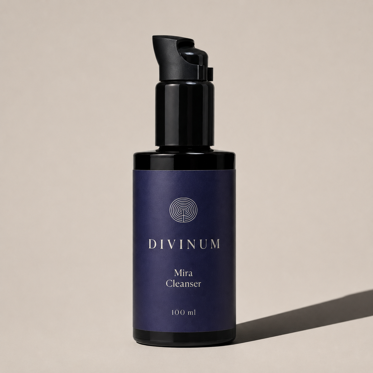 A 100 ml bottle of Divinum Mira Cleanser, featuring a dark purple label and a violet pump dispenser, set against a warm beige background with a soft shadow.