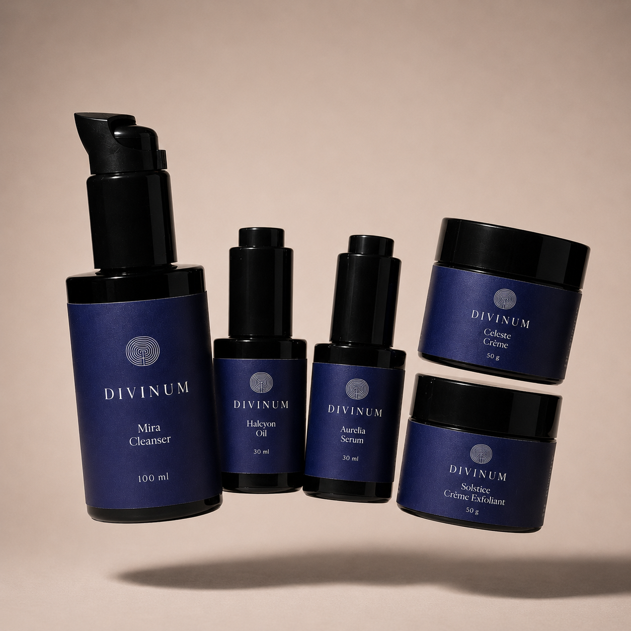 Five Divinum skincare products arranged on a warm beige studio background: a large violet pump bottle labeled Mira Cleanser, two smaller bottles labeled Halcyon Oil and Aurelia Serum, and two jars labelled Celeste Creme and Solstice Creme Exfoliant.