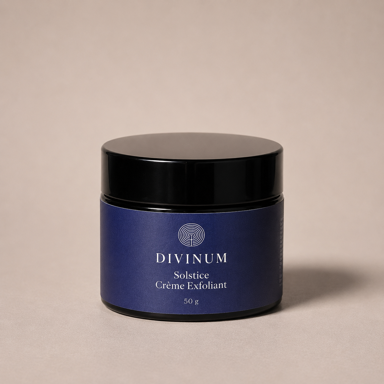 A 50g jar of Divinum Solstice Crème Exfoliant, featuring a deep purple label and a black lid, set against a solid beige background.